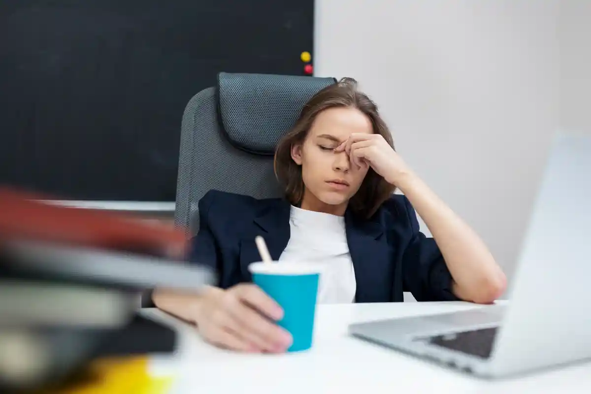 خستگی و بیحالی-خانم جوان در حالت خستگی پشت میز کار